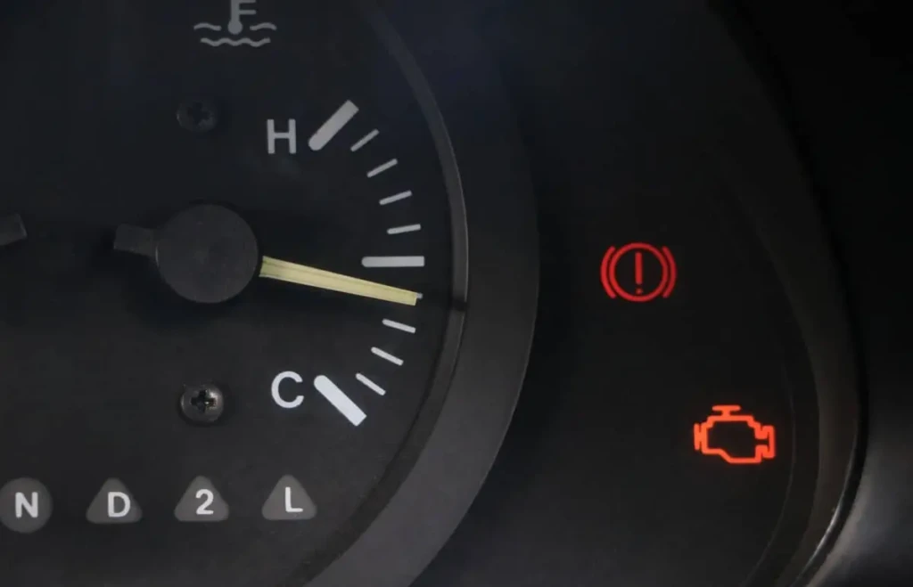 Dashboard warning lights showing engine trouble and brake alert in a vehicle
